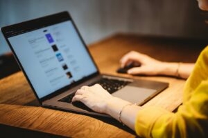 personne utilisant un MacBook Pro sur une table en bois marron