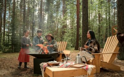 Une famille profitant d'un voyage de camping avec un foyer dans un environnement forestier.