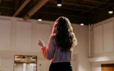 a woman standing in a room holding a remote