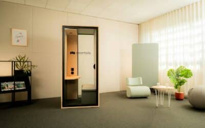 Modern office with soundproof phone booth and seating.