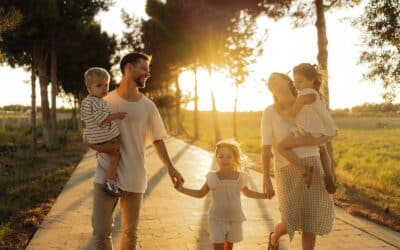 Family walking on path with trees at sunset