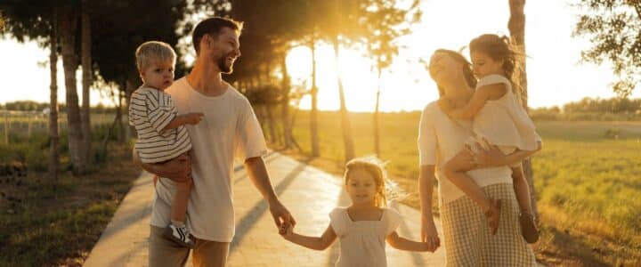 Family walking on path with trees at sunset