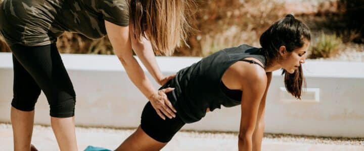 woman in black tank top and black shorts kneeling on mat