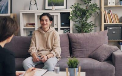 a woman sitting on a couch talking to another woman