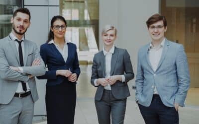 Four professionals in business attire stand together.