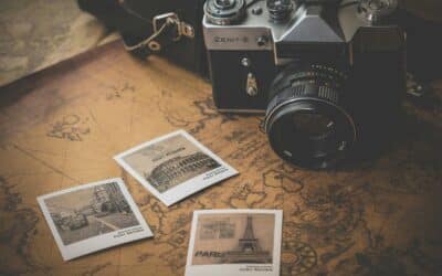 black and grey DSLR camera near several photos on brown map