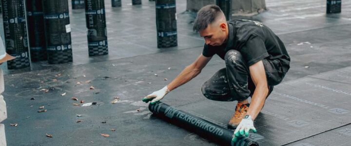 Homme roulant un tube sur un sol en noir
