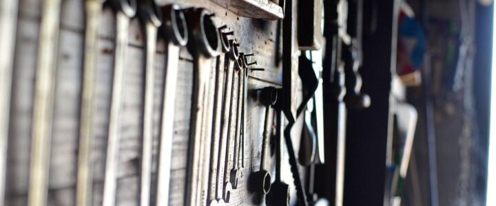 Clés, tournevis et marteau accrochés sur un mur en bois
